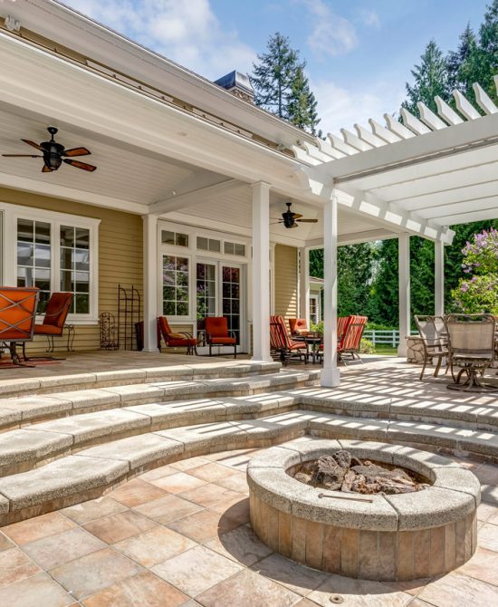 A Pergola and a firepit in the backyard deck made of decorative concrete