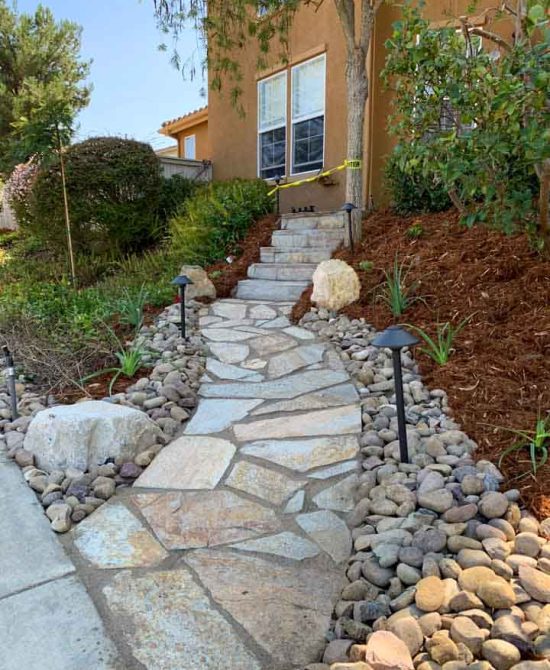 A concrete stair and a decorative stone walkway, in ongoing improvement of the landscape
